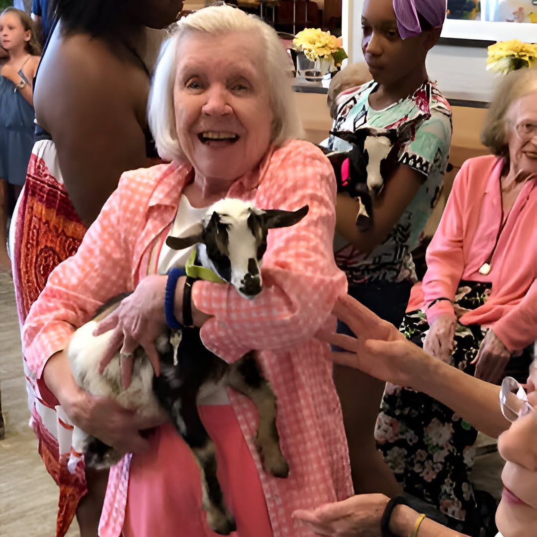 Community member holding baby goat
